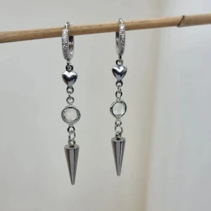 Silverfärgade örhängen med hjärta och kon - Stilrena silverfärgade örhängen med en liten hjärtformad detalj och en klar sten. Handgjorda örhängen●Följ :@ekjewelryofficial🤲 ● 💎Material- 100% rostfritt stål ●Örhängeskrokar -rostfritt stål och kristall. Nickel fri. Längd -5,5cm. Vattentåliga, ändrar inte färgen! 
