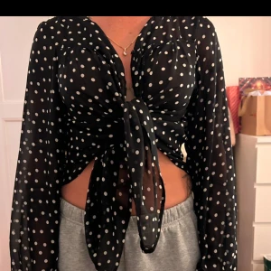 Svart prickig blus  - Snygg svart blus med vita prickar.