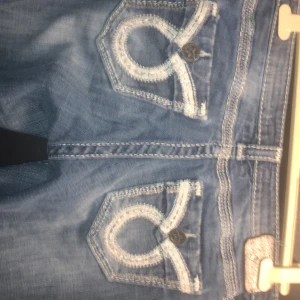 Blå jeans från Big Star - Snygga blå jeans från Big Star med unika broderade detaljer på bakfickorna. De har en klassisk bootcut-stil och i perfekt skick förutom lite slitna  sömmar längst ner bak, se bild. Stl 28 lång.