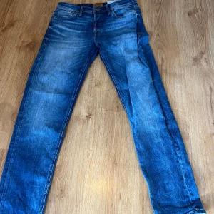 Blå jeans från Jack & Jones - Snygga blå jeans från Jack & Jones med en klassisk femficksdesign. De har en normal passform och är tillverkade i slitstarkt denim. Perfekta för en avslappnad stil. storlek 31/32