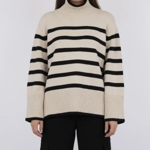 Randig stickad tröja från Neo Noir - Säljer en snygg stickad tröja från Neo Noir i beige och svart. Tröjan har ett randigt mönster och en hög krage och slits på sidorna. Perfekt julklapp!! Nypris 1000 kr.