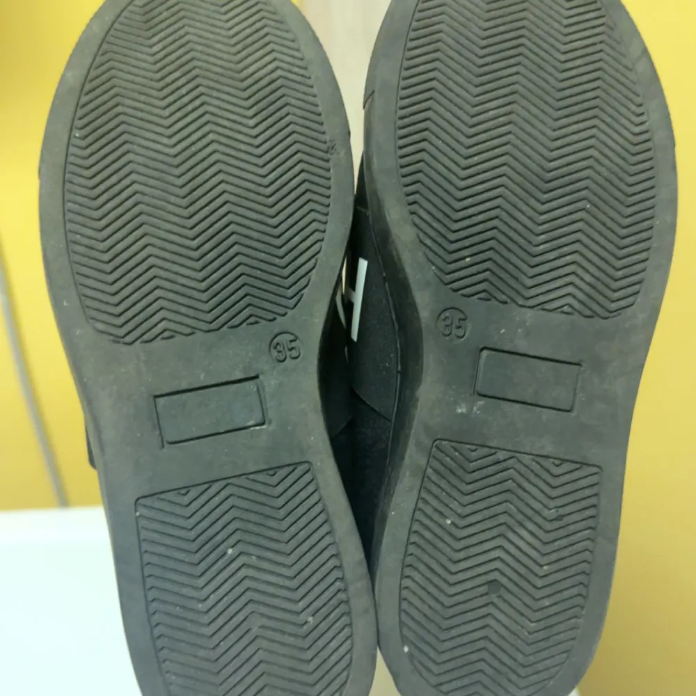 Snygga svarta sneakers från Hugo Boss med bred resårrem över foten med logotyp. Skorna har en stilren design och är perfekta för en avslappnad look.. Kengät.