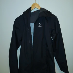 Svart vindjacka från Haglöfs - Hej! Jag säljer min haglöfs jacka som kostade 2000 kr den är nästan helt oanvänd o är i gott skick jag säljer pga fel strl. Strl M jag säljer den för 1000 kr. Priset kan diskuteras. Jag tar swish Finns I Huddinge Centrum.