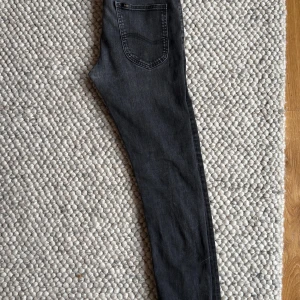 Lee Jeans (Luke) Svart - Snygga svarta jeansbyxor med tvättade detaljer. Sitter väldigt slim. W33 L32