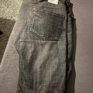 J. Lindberg jeans - Snygga grå jeansbyxor med en klassisk femficksdesign. Perfekta för en avslappnad stil. De har en slim/straight passform och är tillverkade i ett slitstarkt material. Säljs för sjuka priset 149. Fast pris