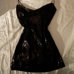 Vintage svart glitter/paljett linne  - Snygg mörkt linne med paljetter som ger en glittrig look. Den har smala axelband som är stretchiga, perfekt för en kväll ute. 