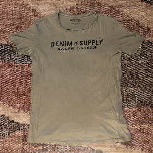 Denim & Supply Ralph lauren t-shirt  - En sjukt skön och snygg Ralph Lauren denim & supply t-shirt i en olivgrön färg som har ett stilrent tryck som passar bra till det mesta. Otroligt bra skick inga defekter väldigt sparsamt använd! Hör av dig vid eventuella frågor eller funderingar!