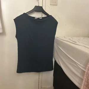 Marinblå  ärmlös topp  - Säljer en stilren svart ärmlös topp. Perfekt för en minimalistisk look och lätt att matcha med olika outfits. Toppen har en enkel design med rund halsringning.