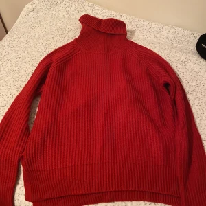 Röd stickad polotröja från Amisu - Säljer en snygg röd stickad polotröja från Amisu. Perfekt för kyliga dagar med sin höga krage och långa ärmar. Tröjan har en ribbad struktur som ger en stilren look.  Pris kan diskuteras!