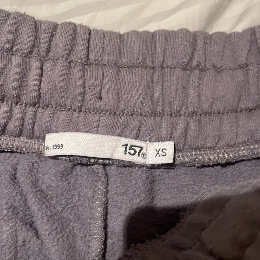 Säljer ett par bekväma grå mjukisbyxor i storlek XS. Byxorna har en elastisk midja med snörning och praktiska fickor framtill. Perfekta för en avslappnad stil.. Farkut & Housut.
