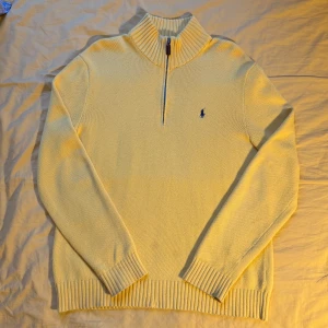 Gul stickad half-zip tröja från Polo Ralph Lauren - Säljer en snygg vintage gul stickad half-zip tröja från Polo Ralph Lauren med ribbad krage. Tröjan är i bra skick bortsett från 2 små fläckar på framsidan. Pris kan diskuteras