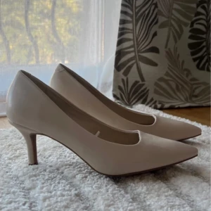Beige pumps med spetsig tå - Här har vi ett par eleganta ljus begie färgade pumps som är helt oanvända pågrund av fel storlek. Väldigt snygga skor med en skön sula invändigt. Perfekta för en stilren look.   Klackhöjden är 7 cm