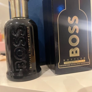 Bottled Parfym från Boss - Säljer en elegant parfymflaska från Boss, Bottled Triumph Elixir. Flaskan är svart med guldtext och har en stilren design. Perfekt för den som vill ha en sofistikerad doft i sin samling. Helt ny köpte fel o kan tyvär inte lämna tillbacka kan diskuteras om priset 