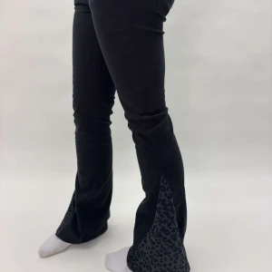 Svarta bootcut byxor med leoparddetaljer - Svarta omgjorda skinnyjeans till bootcut byxor med leopardmönstrade detaljer vid bensluten. Modellen är 167 cm lång🙌