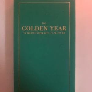 The Golden Year: Ta makten över ditt liv på ett år - En inspirerande bok med titeln 'The Golden Year' som hjälper dig att ta kontroll över ditt liv på ett år. Boken har en elegant grön omslag med gyllene text. Perfekt för dig som vill göra en förändring och nå dina mål.