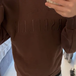 brun sweatshirt med tryck - säljer en brun sweatshirt med texten 'Marseille' på framsidan. Tröjan har långa ärmar och en rund halsringning i storlek xxs från gina tricot