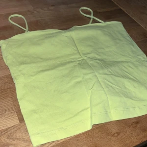 Gul grönt linnetopp från Gina Tricot - Säljer en söt gul grönt linnetopp från Gina Tricot. Toppen har smala axelband och är perfekt för varma dagar. Den är tillverkad i ett mjukt och bekvämt material.