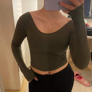 Olivgrön långärmad topp - Säljer en olivgrön långärmad topp med öppen rygg. Från chiquelle.