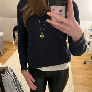 Mörkblå stickad tröja - Säljer en stilren mörkblå stickad tröja med långärmad design. Perfekt för kyligare dagar och enkel att matcha med olika outfits. Tröjan har en klassisk passform och är ett måste i garderoben.