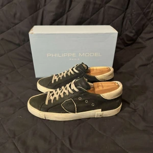 Philippe Model - Snygga mörk gröna skor från Philippe Model med vita detaljer och snörning. Skorna har en klassisk design med en bekväm passform och är perfekta för en stilren look. Skick 7/10 dem är i bra skick men deffekter finns (sista bilden). Box medkommer vid köp.