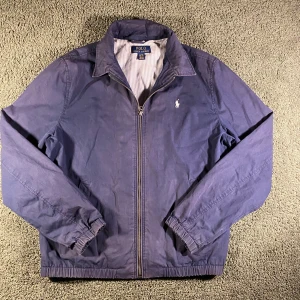 Ralph Lauren windbraker marinblå  - Ralph Lauren wind breaker jack marinblå Skick 8/10, inga skador! Lite solblekta fläckar, ej särskilt märkvärdigt vid användning. Storlek: XL 18-20 ungdom = XS~.•mått, axel-neråt: 57cm, bredd: 47cm. Modell: 173cm, 63kg