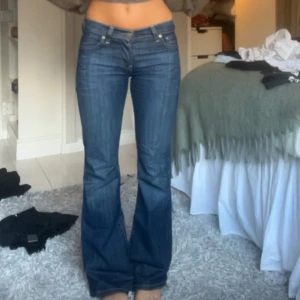 Blå Levis jeans - Snygga blå Levis jeans med bootcut-stil. De är lågmidjade och i bra skicka. Midjemått 37 och innerbenslängd 80