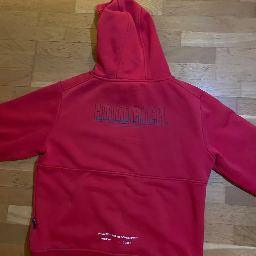 Säljer en snygg röd hoodie från Hoodrich. Den har en stor ficka fram och en cool logga på bröstet. Perfekt för chilliga dagar eller när du vill ha en avslappnad stil. Den är i bra skick med bara några små tecken på användning. Passar perfekt till jeans eller joggers!. Hoodies.