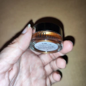 Glam Cream Color från Bang Beauty - Säljer en superfin Glam Cream Color från Bang Beauty. Den har en härlig, skimrande bronsfärg som är perfekt för att ge lite extra glow till din look. Kommer i en smidig liten burk som är lätt att ta med sig. Perfekt för både vardag och fest!