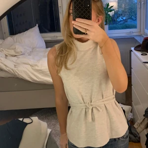 Zara topp - Säljer denna beiga topp i nyskick som är såå fin! Den är köpt på zara men finns inte kvar längre💓 Man kan knyta snöret på massor olika sätt eller inte ha det alls💕