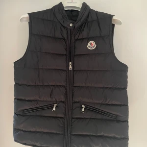 Moncler väst - Säljer min Moncler väst i storlek 14years (164cm) men motsvarar en S, pågrund av att den inte kommer till användning. Köpt på NK i Göteborg och har inga defekter💗