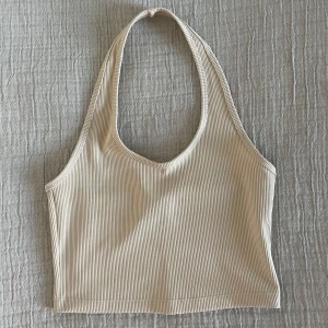 Beige halterneck topp - Beige halterneck topp från H&M, storlek M men passar S också. Jättefint skick, oanvänd! Passar till vardags, fest, träning, allt 😍
