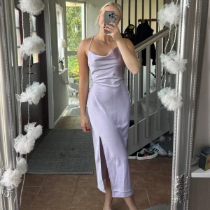 Lila satinklänning  - Lila satinklänning i midimodell och öppen rygg 