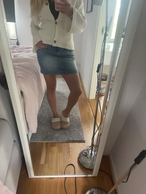 Blå jeanskjol i kort modell - Säljer en klassisk blå jeanskjol i kort modell. Kjolen har en rak passform och är tillverkad i denim med snygga sömdetaljer. Perfekt att matcha med en stickad tröja eller t-shirt för en avslappnad look.