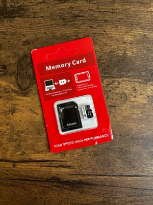 Minneskort med adapter 2TB - Säljer ett minneskort på 32GB tillsammans med en SD-adapter. Perfekt för att lagra bilder, filmer eller andra filer. Kommer i originalförpackning med röd bakgrund. Passar till mobil, kamera eller annan elektronik.