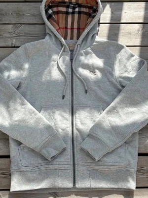 Burberry Hoodie - Säljer nu denna avssnygga Burberry Hoodie. Tröjan är endast använd ett fåtal gånger och har inga defekter. Hör av er vid frågor eller funderingar!