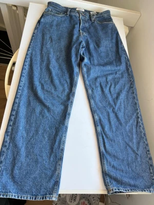 Blåa baggy jeans från jack & Jones - Klassiska blå jeans med rak passform och hög midja. Jeansen har fem fickor och stängs med dragkedja och knapp. Tillverkade i denim med en snygg tvättad look. Perfekta för en avslappnad och trendig stil. Bara använda 2-3 gånger 