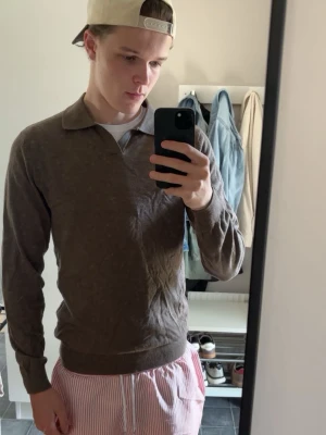 Brun stickad tröja med krage - Mysig brun stickad tröja med klassisk krage och långa ärmar. Tröjan är perfekt till att ha skjorta under eller bara till vardags, andvänd 1 gång men är för liten därav säljer jag den