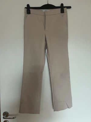 Beige raka kostymbyxor - Jättesnygga kostymbyxor från Zara.   Inköpta på barnavdelningen.   Jag är 159cm och dem passar mig. De ska vara lite kortare än normalt i längden.   Av någon anledning kom dem med ritat bläck i fickorna, säkerligen något fabriksfel. Syns endast om fickan blir uttöjd.   Längd: ca 83-84 cm Midja: ca 34-35 cm