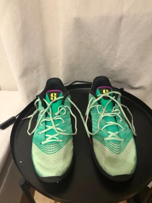  Nike Sabrina 3 basketskor - Säljer ett par Nike Sabrina 3 med svart sula och detaljer i lila och gult. Skorna har en sportig design med meshmaterial för bra ventilation och snörning framtill. Perfekta för träning och springa. De är använda ungefär 5-10 gånger och är i STORLEK 45-45,5👍🏼