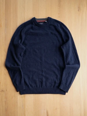Mörkblå stickad tröja rund hals - Mysig mörkblå stickad tröja med rund halsringning och ribbade muddar vid ärmslut och nederkant. Perfekt för lager på lager och enkel att matcha till olika outfits. Materialet känns mjukt och följsamt. 