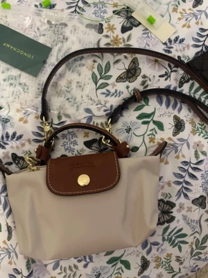 Beige mini  väska från Longchamp - Mini väska från longchamp. Helt ny, nypris 1299kr, mitt pris 599kr💕