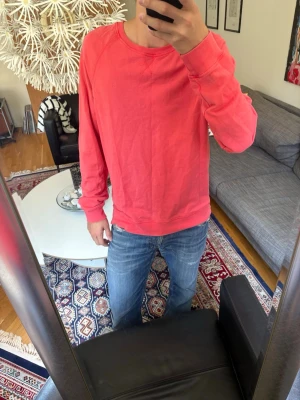 Korall sweatshirt med rund hals - En enkel och snygg korall sweatshirt med rund hals och långa ärmar. Tröjan har ribbade muddar vid ärmslut och nederkant. Perfekt för en avslappnad stil och passar till det mesta i garderoben.