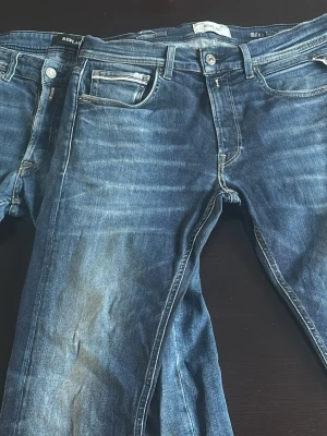 Två par Replay jeans, grover  - Säljer två par klassiska blå jeans från Replay med raka ben och femficksmodell. Jeansen har tydliga slitningar och kontrastsömmar samt läderpatch bak i midjan. Den mörklblåa varianten har ett hål o backfickan. Annars bra skick 