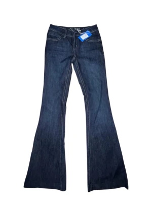 Mörkblå bootcut jeans - Säljer ett par mörkblå lågmidjade bootcut jeans från DLI961 köpta från Sellpy helt nya och oanvända. Jeansen har en snygg utsvängd passform. 