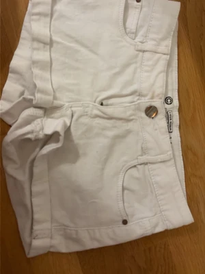 Vita low/mid waist shorts med fickor - Jag säljer dessa snygga vita low/mid waist shortsen från Cubus som är i fint skick utom att loggan nästan gått bort💕 de är i storlek 146💕 skriv vid minsta fundering