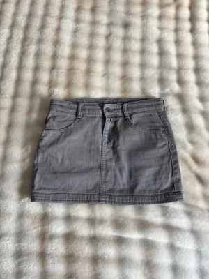 Grå jeanskjol - Snygg grå kort jeanskjol med klassiska fem fickor och bälteshällor. Kjolen har knapp- och dragkedjestängning framtill och är tillverkad i ett slitstarkt bomullsmaterial. Perfekt att matcha med en enkel topp eller hoodie. Köpt för 399 kr!💓