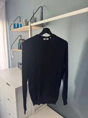 Mörkblå stickad tröja WE - En stilren mörkblå stickad tröja med rund hals och långa ärmar. Tröjan har ribbade muddar vid ärmslut och nederkant. Pris kan diskuteras vid snabb affär