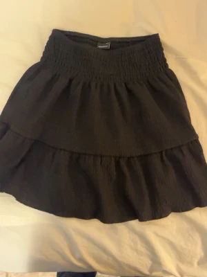 Svart kjol från Gina Tricot - En fin, svart, medel lång kjol från Gina tricot. Väldigt bra skick har knappt använt den. Perfekt om man bara vill ha något som passar till allt! 