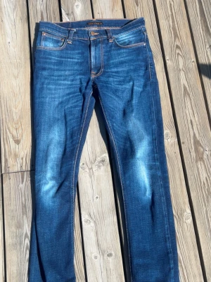 Blå jeans från Nudie Jeans - Säljer ett par riktigt feta nudie jeans i moddelen lean dean storlek är 29 32 och har riktigt skön passform. Skicket är väldigt bra då de knappt är använda.