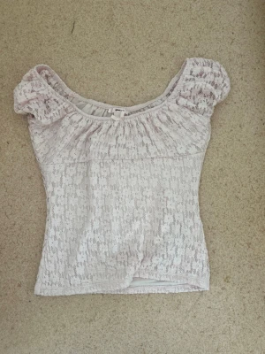Ljusrosa spetsblus från Gina Tricot - Supersöt ljusrosa topp från Gina Tricot med puffärmar och spetsdetaljer. Toppen har en liten rosett framtill och är perfekt för dig som gillar romantisk stil. Passar dig som vill ha något unikt och feminint i garderoben. Den är lite mer rosa i verkligheten än vad den är på bilderna 🫶🏻